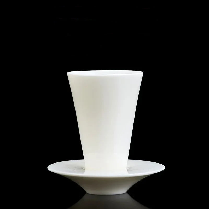 Tasse à thé conique posée sur sa soucoupe assortie, sur fond noir