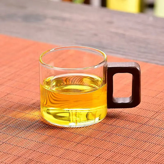 Tasse à thé en verre borosilicate à anse en bois, remplie de thé vert