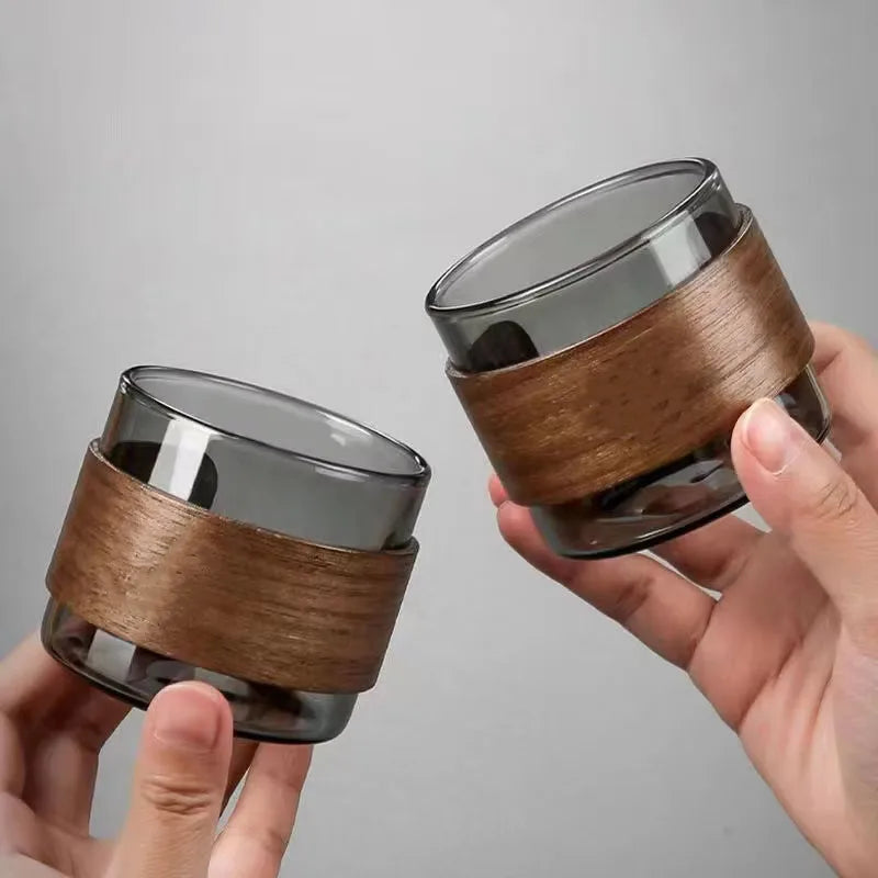 Deux tasses à thé en verre, coloris fumé et transparent, tenues côte à côte
