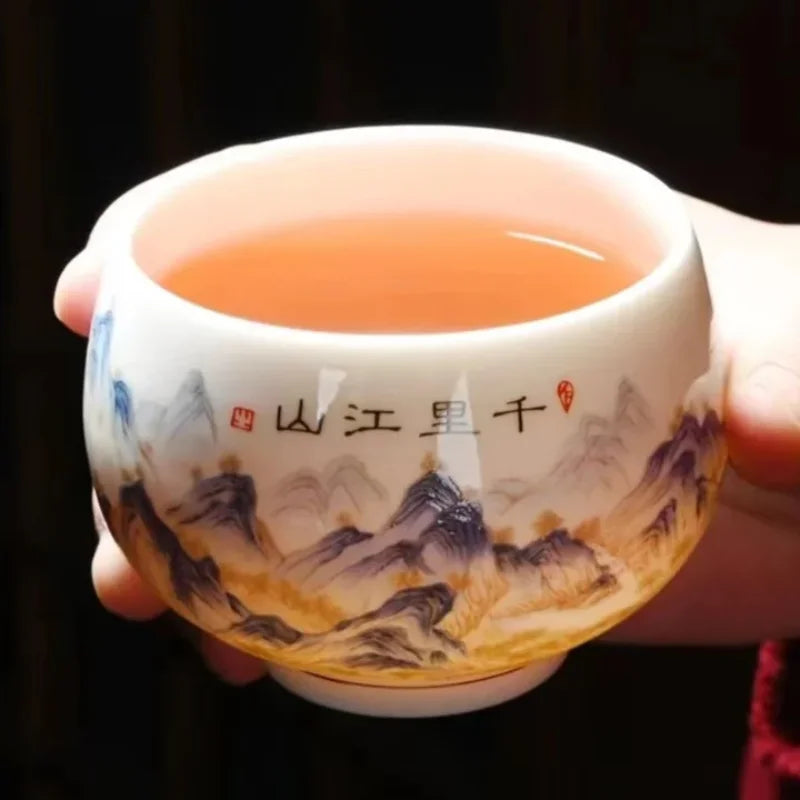 Tasse à thé en porcelaine blanche remplie de thé ambré, tenue à deux mains