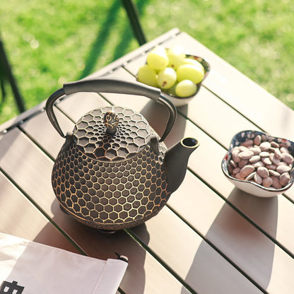 Théière en fonte motif doré avec dessous-de-plat offert