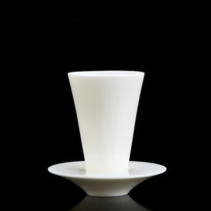 Tasse à thé conique posée sur sa soucoupe assortie, sur fond noir