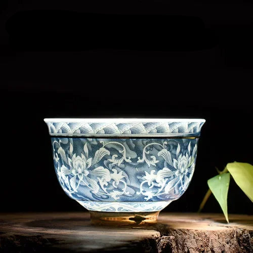 Petit bol à thé en porcelaine bleu et blanc à décor floral, sur un socle en bois