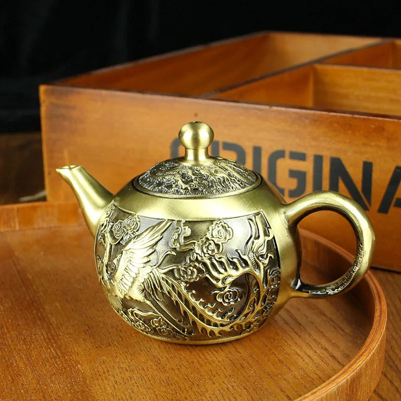 Détail gravure artisanale dragon sur théière en cuivre