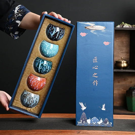 Coffret de cinq tasses à thé en céramique aux glaçures colorées, présenté ouvert