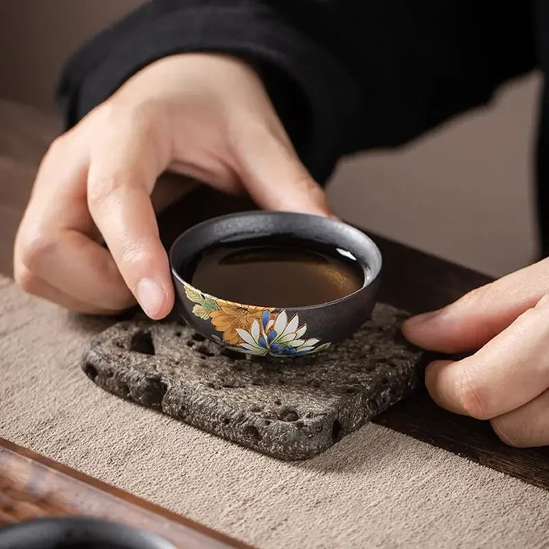 Tasse à thé remplie posée sur un socle en pierre gravée