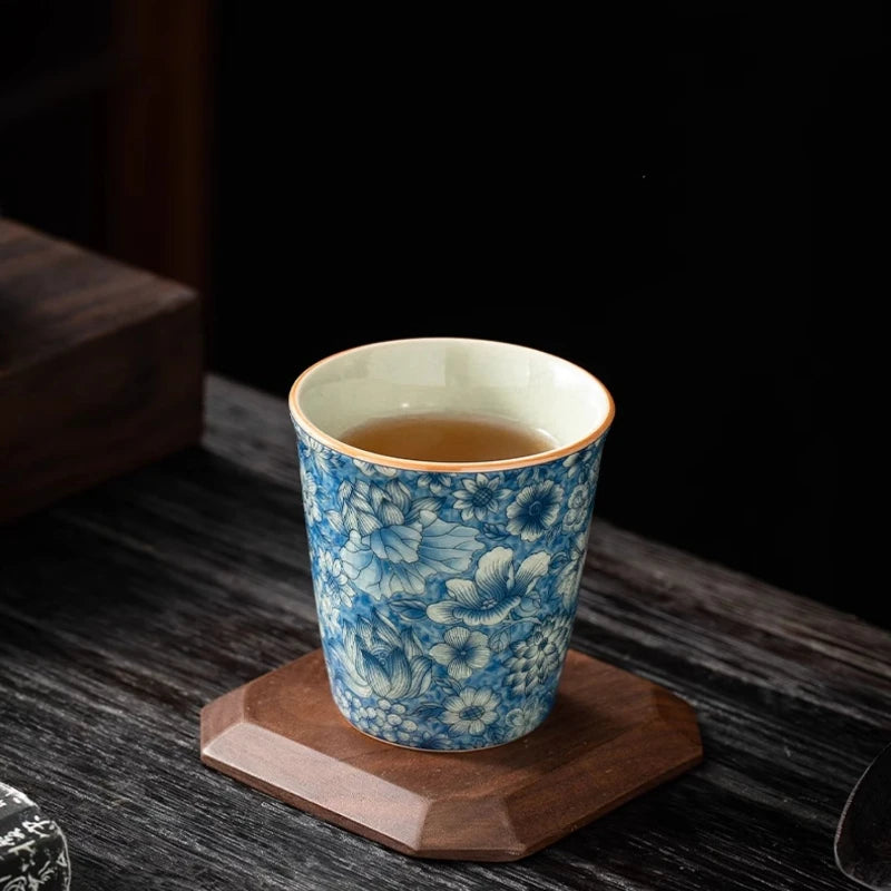 Tasse à thé remplie d'infusion posée sur un dessous de tasse en bois