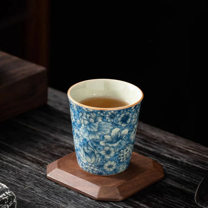 Tasse à thé remplie d'infusion posée sur un dessous de tasse en bois
