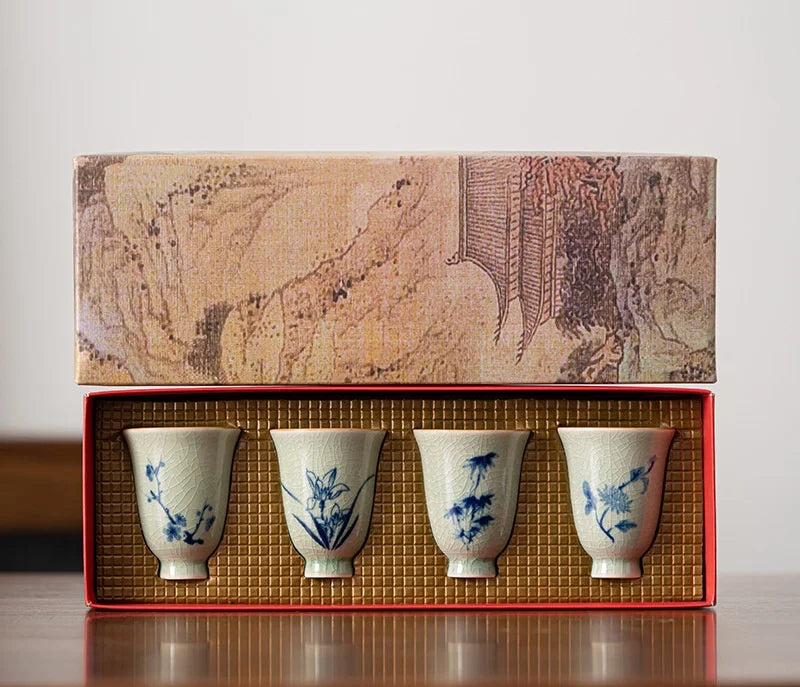 Coffret ouvert présentant les quatre tasses à thé aux motifs de plantes