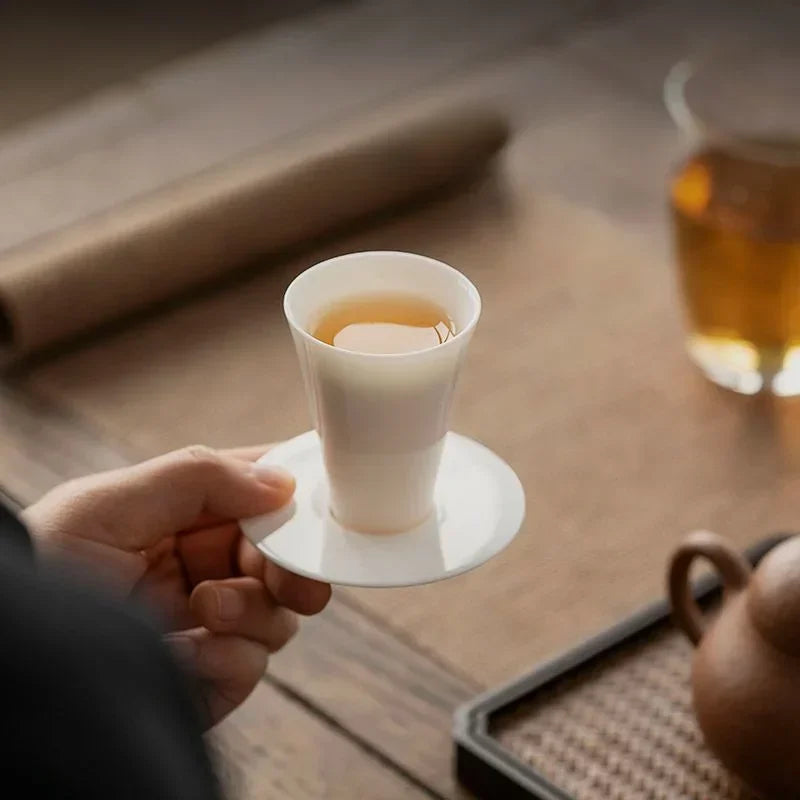 Tasse à thé et soucoupe en porcelaine saisies sur une table à thé