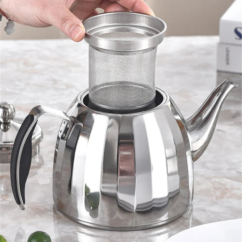 Théière inox brillant sur table vue de trois quarts