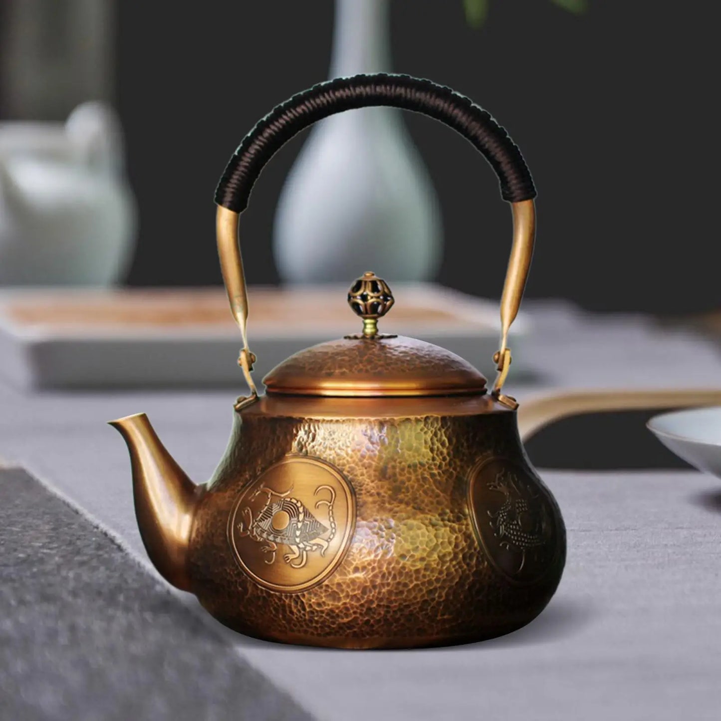 Théière cuivre martelé posée sur table élégante