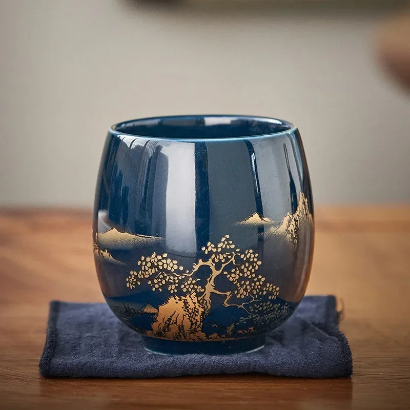 Tasse à thé émail noir profond posée sur un carré de tissu bleu