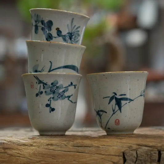Les quatre motifs floraux de tasses à thé en céramique, alignés sur une poutre