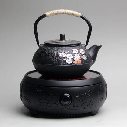 Théière en fonte fleurie posée sur table en bois