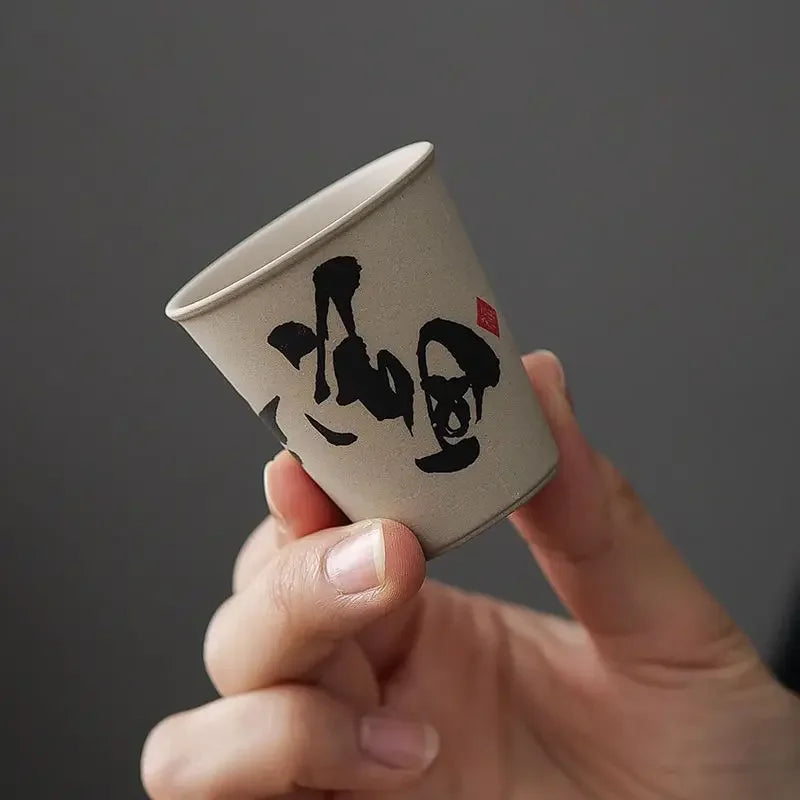 Gros plan d'une tasse à thé en céramique à décor calligraphié