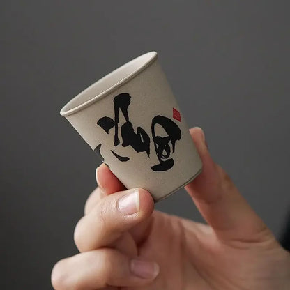 Gros plan d'une tasse à thé en céramique à décor calligraphié