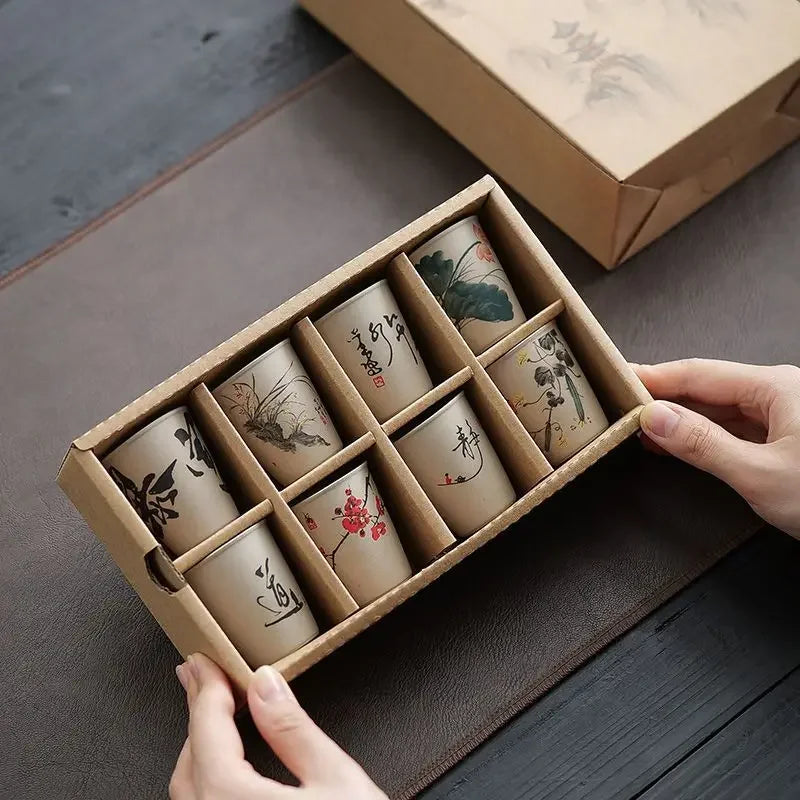 Coffret kraft ouvert contenant les huit tasses à thé dans leurs logements