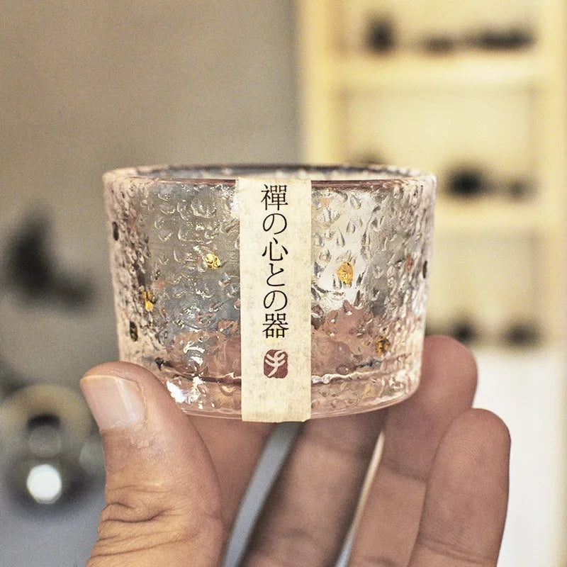 Tasse à thé en verre martelé tenue en main, avec son bandeau japonais