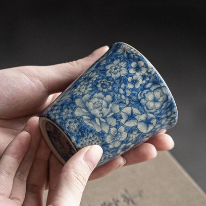 Tasse à thé au décor bleu et blanc tenue au creux de la main