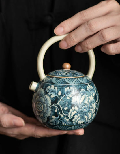 Détail motifs floraux bleus peints main théière céramique