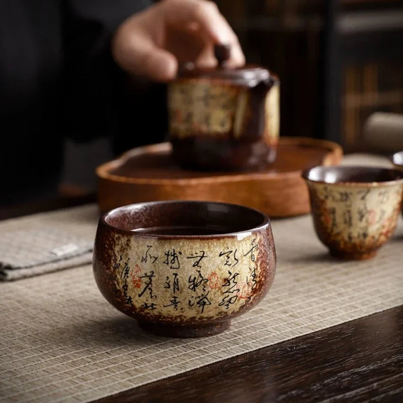 Deux tasses à thé en poterie et une théière posées sur un chemin de table