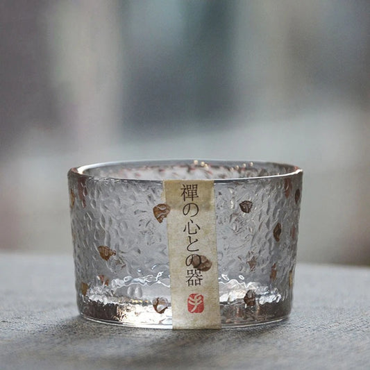 Tasse à thé en verre martelé à éclats dorés posée sur une pierre