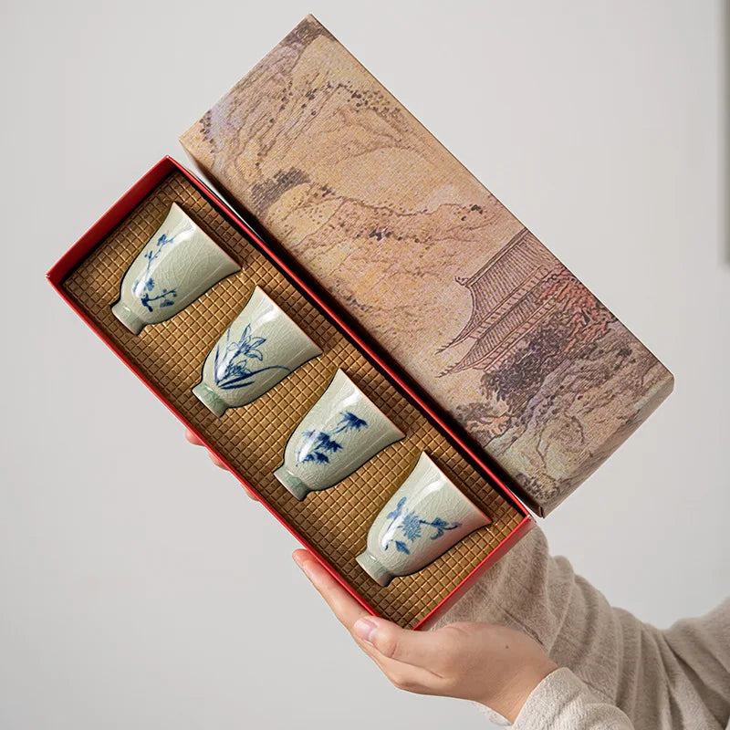 Coffret des quatre tasses à thé céladon tenu ouvert à deux mains