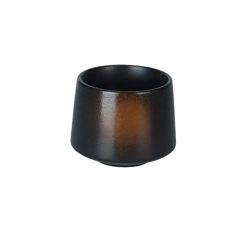 Tasse à thé en céramique noire aux reflets cuivrés, sur fond blanc