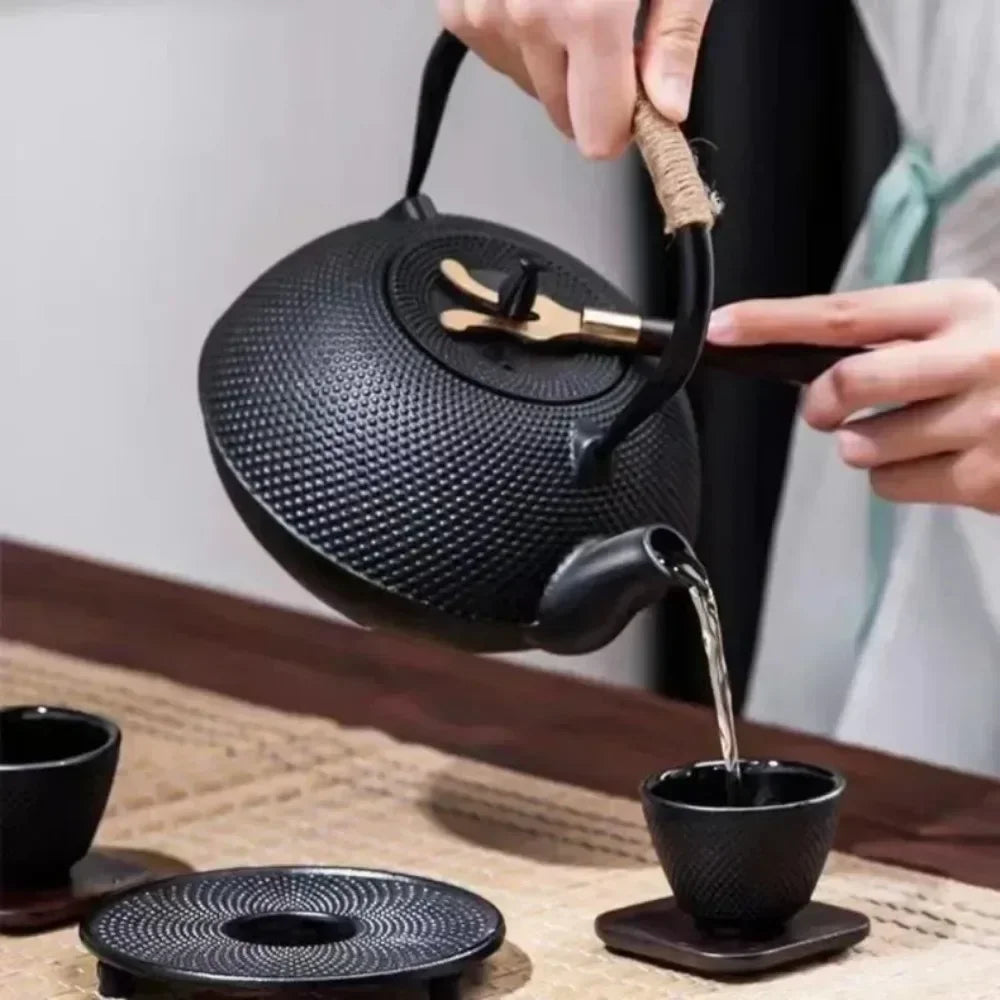 Théière fonte perlée noire posée sur table en bois