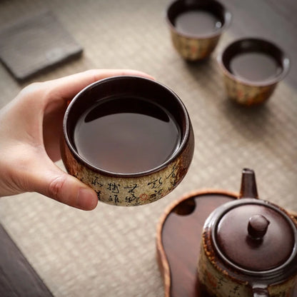 Tasse à thé en poterie remplie, tenue au-dessus du plateau de service