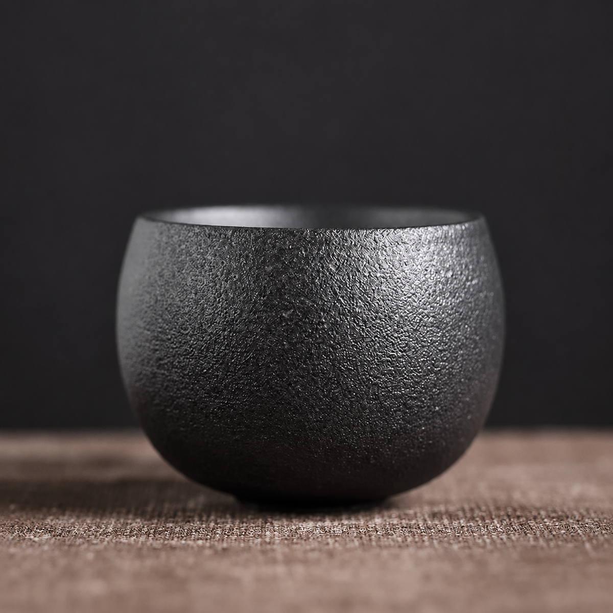 Tasse à thé en grès coloris noir à la surface granuleuse